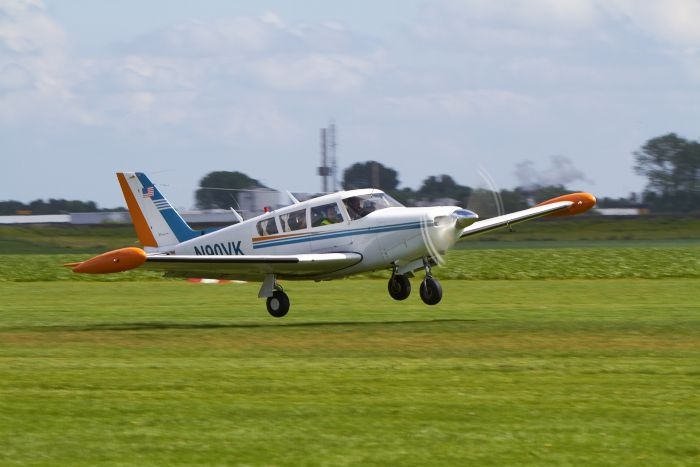 De Piper Comanche N90VK is hier net los tijdens het Midzomer Event op vliegveld Midden Zeeland. Op de achtergrond is de frietfabriek van McCain in Lewedorp zichtbaar.