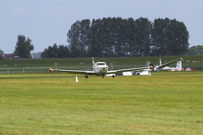 Piper Comanche N90VK opgelijnd op baan 27 op vliegveld Midden Zeeland tijdens het Midzomer Event.