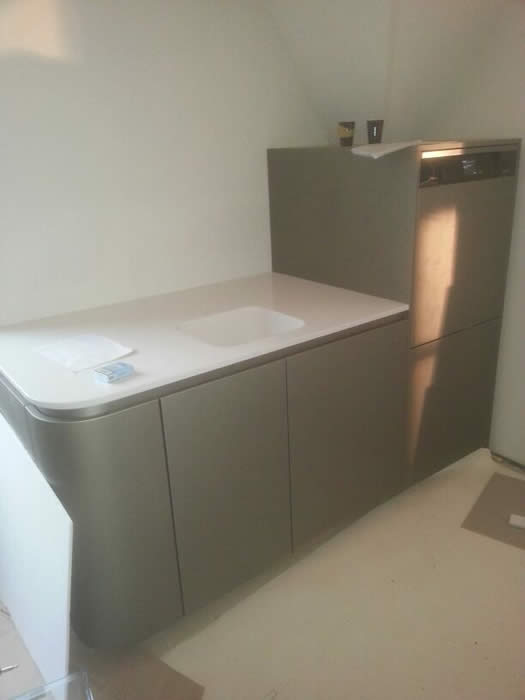 Achter het eiland staat een extra keuken tegen de wand als het ware als een "spoelkeuken". 