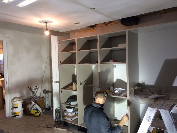 Monteur Jan plaatst de hoge kasten van de nieuwe keuken.